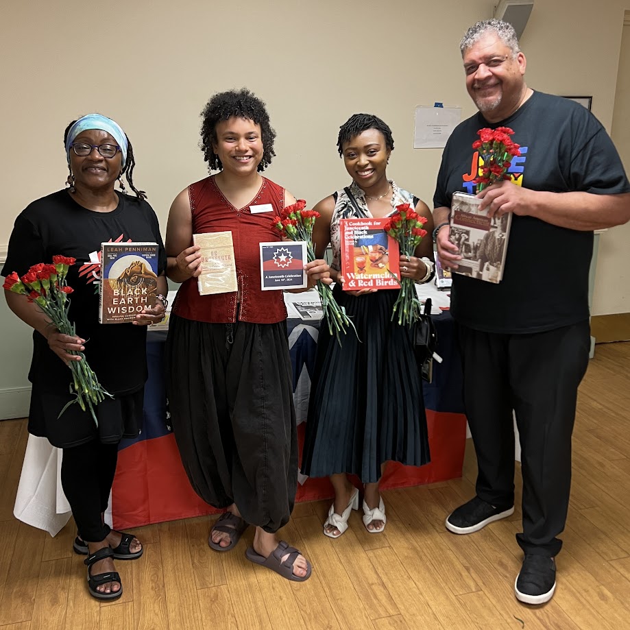 Juneteenth event showing four participants holding books and smiling at the camera