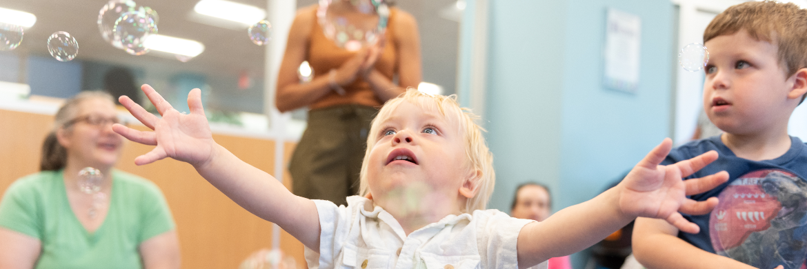 Two children in the library, a baby and toddler boy