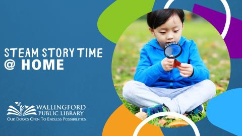 Boy sitting outside holding a magnifying glass examining a leaf