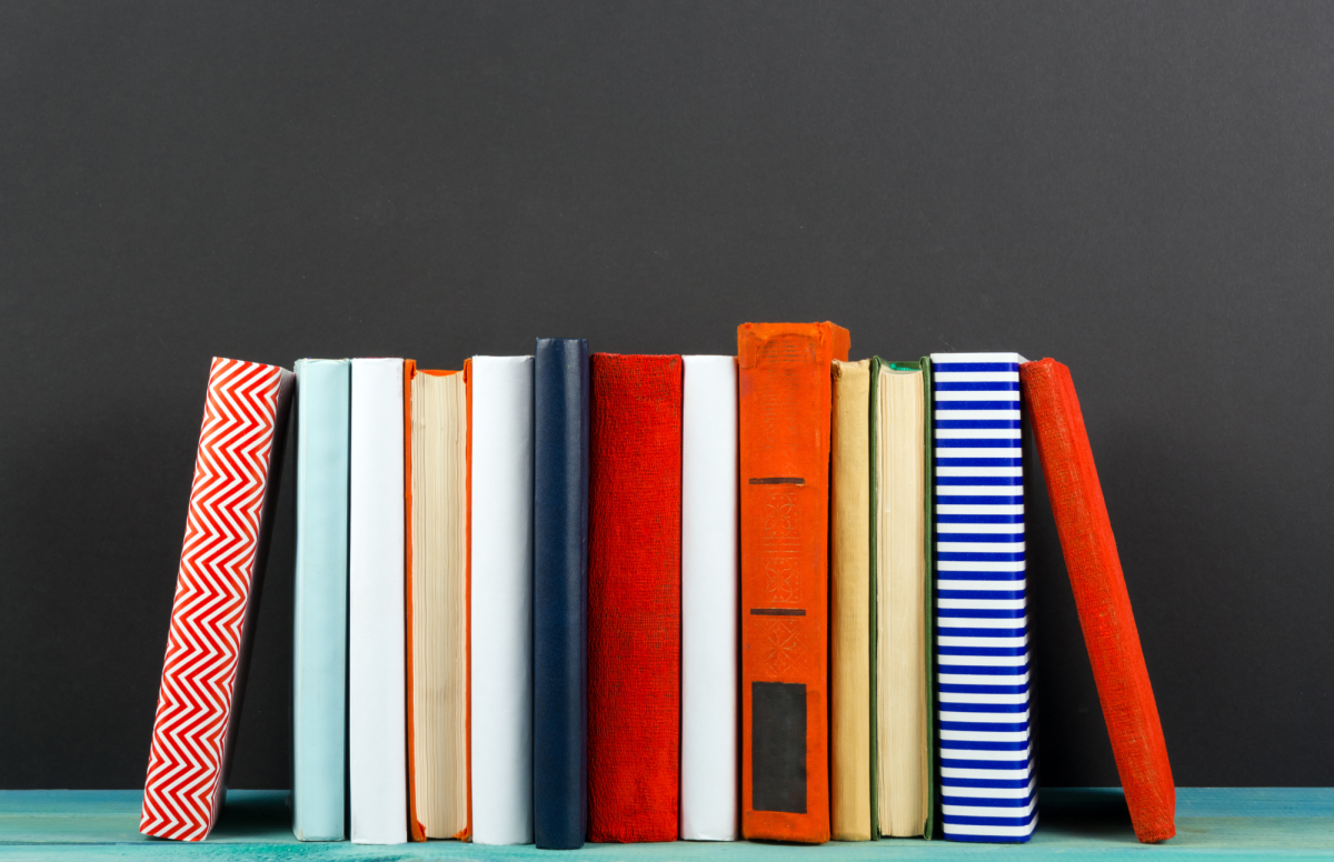 Row of colorful books standing up on a shelf